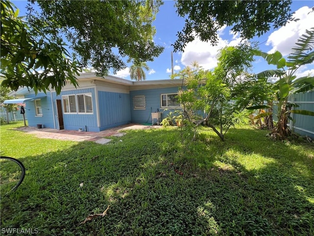 rear view of property with a yard