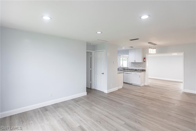 unfurnished living room featuring sink and light wood-type flooring