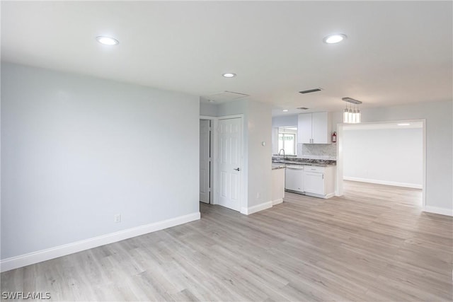 unfurnished living room with sink and light hardwood / wood-style flooring