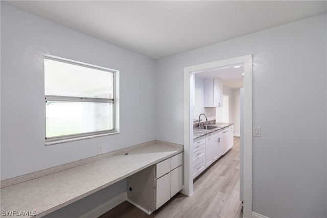 interior space with sink, light wood-type flooring, and built in desk