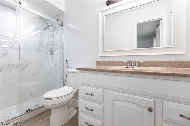 bathroom featuring vanity, an enclosed shower, wood-type flooring, and toilet