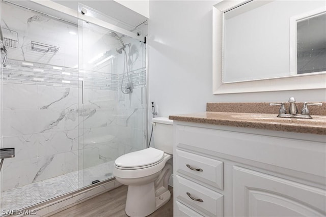 bathroom with vanity, wood-type flooring, a shower with door, and toilet