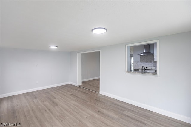 unfurnished room featuring sink and hardwood / wood-style floors