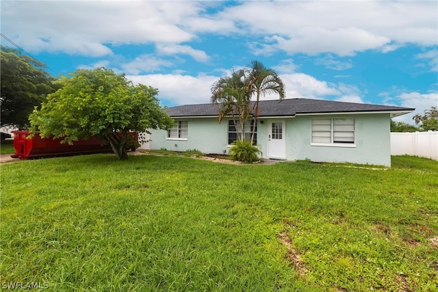 rear view of property featuring a lawn