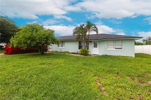 rear view of property featuring a lawn