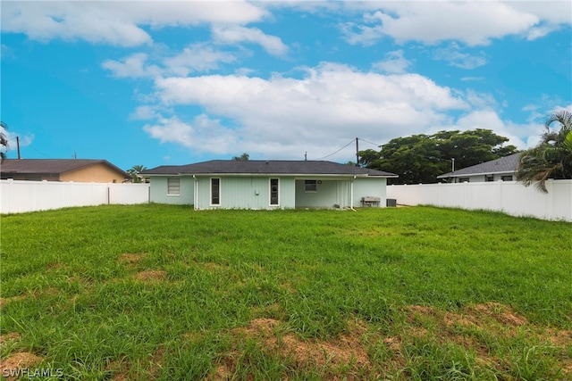 rear view of property featuring a lawn