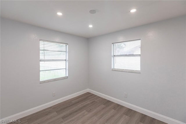 spare room with wood-type flooring and a wealth of natural light