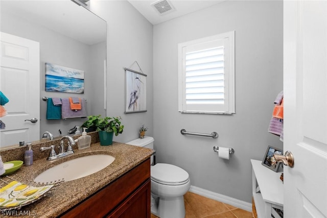 bathroom with visible vents, baseboards, toilet, vanity, and tile patterned flooring