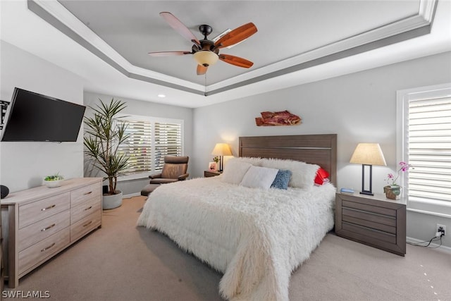 bedroom with light colored carpet, a raised ceiling, baseboards, recessed lighting, and a ceiling fan