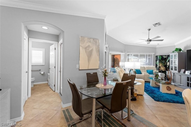 dining space with vaulted ceiling, ornamental molding, and light tile patterned flooring