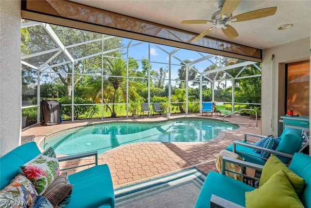 outdoor pool with an outdoor living space, glass enclosure, a ceiling fan, and a patio area