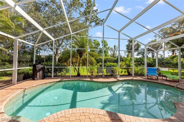 outdoor pool with glass enclosure and a patio area