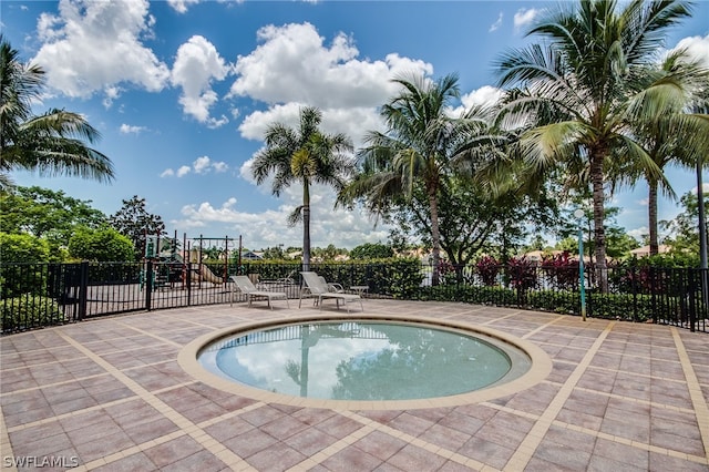 view of swimming pool featuring a playground and a patio area