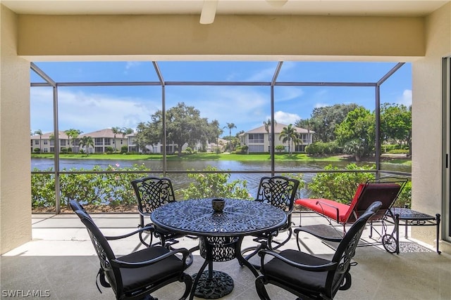 view of patio with a water view and glass enclosure