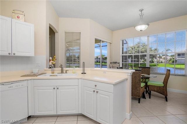 kitchen featuring white dishwasher, sink, pendant lighting, and white cabinetry