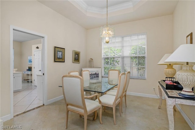 tiled dining area with ornamental molding, a chandelier, and a tray ceiling