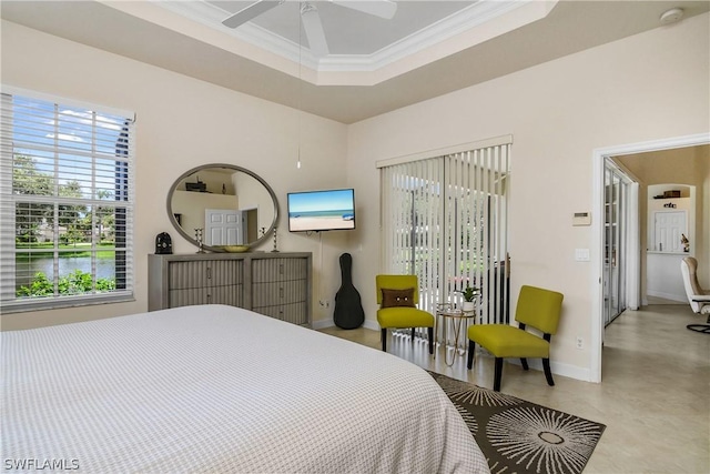 bedroom with ornamental molding, a water view, ceiling fan, and a tray ceiling