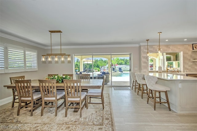 dining area featuring light tile patterned floors, sink, and crown molding