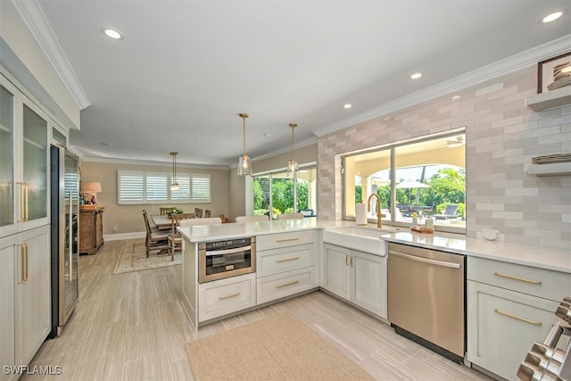 kitchen featuring appliances with stainless steel finishes, decorative light fixtures, crown molding, kitchen peninsula, and light tile patterned flooring