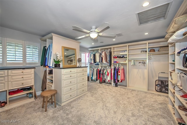 walk in closet featuring ceiling fan and light colored carpet