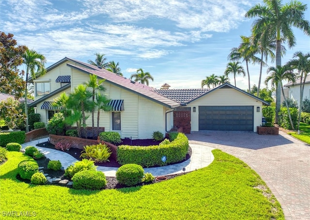 single story home with a front yard and a garage