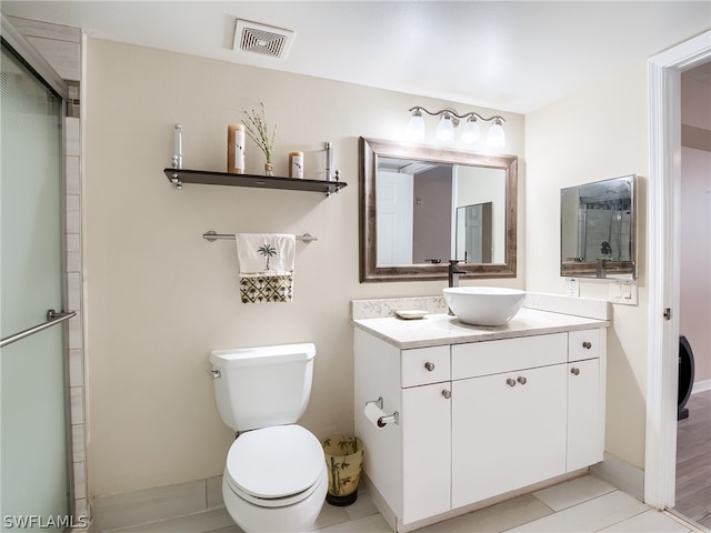 bathroom with tile patterned floors, vanity, toilet, and walk in shower