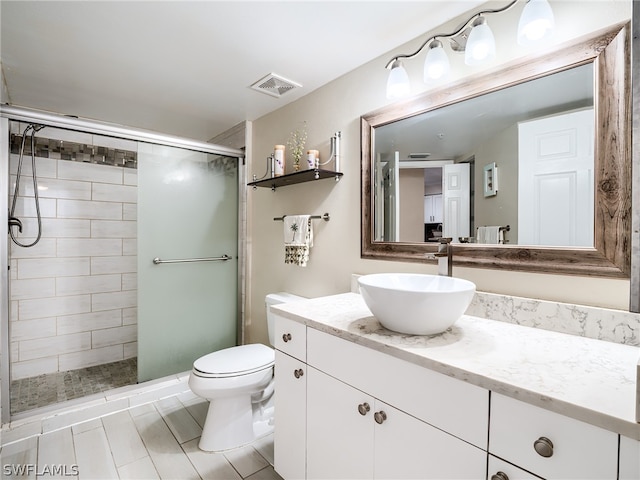 bathroom featuring vanity, an enclosed shower, and toilet