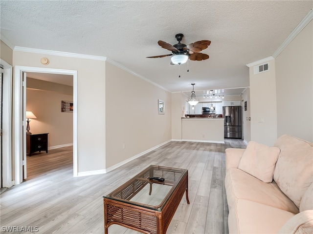 living room with ornamental molding, a textured ceiling, and light wood-type flooring