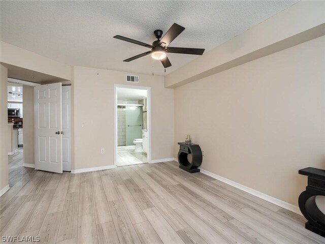 spare room featuring ceiling fan, a textured ceiling, and light wood-type flooring