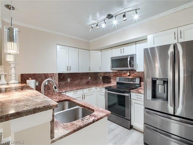 kitchen with kitchen peninsula, stainless steel appliances, crown molding, sink, and white cabinetry