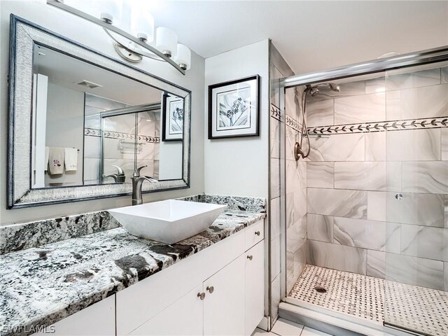 bathroom featuring tile patterned floors, vanity, and a shower with shower door