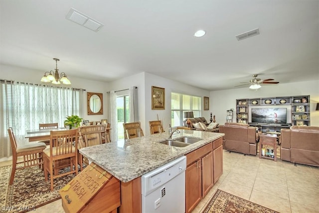 kitchen with light stone countertops, a kitchen island with sink, sink, decorative light fixtures, and dishwasher