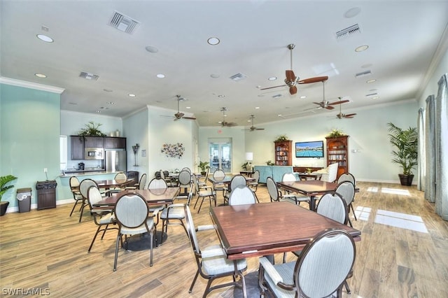 dining room with light hardwood / wood-style flooring and ornamental molding