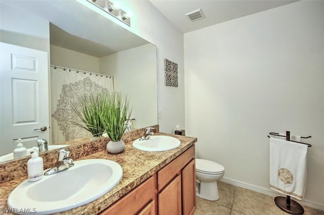 bathroom featuring tile patterned floors, vanity, and toilet