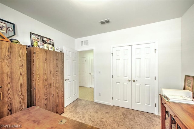 bedroom featuring light carpet and a closet