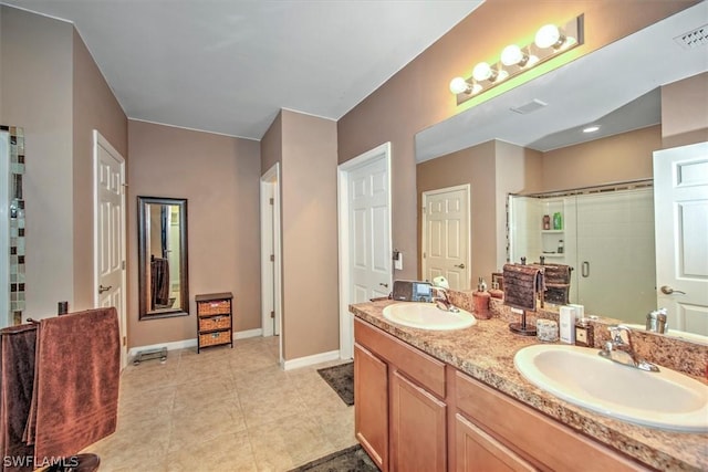 bathroom featuring tile patterned floors, a shower with door, and vanity