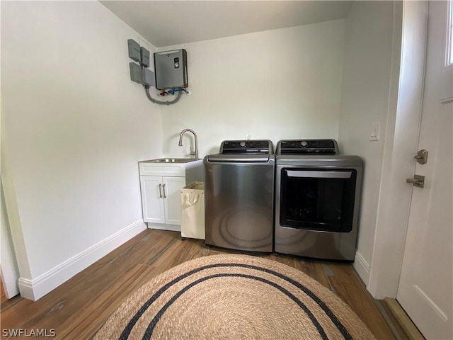 laundry area with washer and clothes dryer, cabinets, sink, and dark wood-type flooring