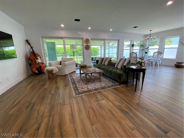 living room featuring wood-type flooring and a notable chandelier