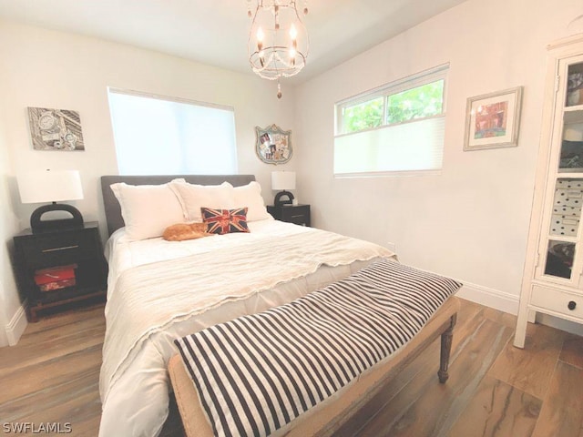 bedroom with a notable chandelier and dark hardwood / wood-style flooring