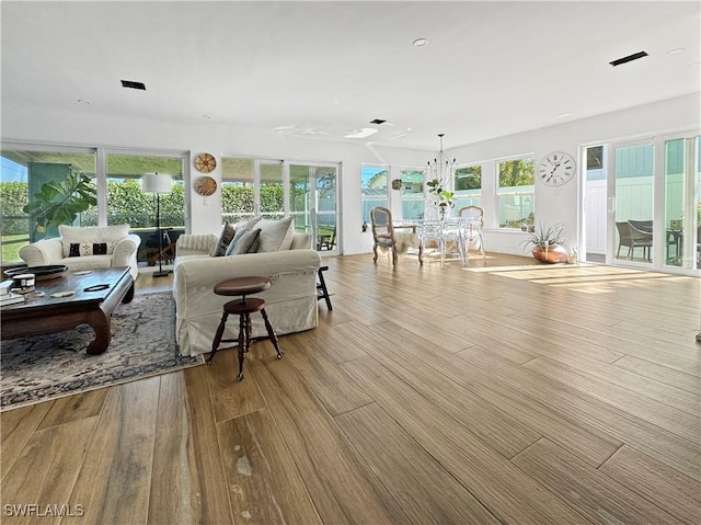 living room featuring light wood-type flooring and a notable chandelier