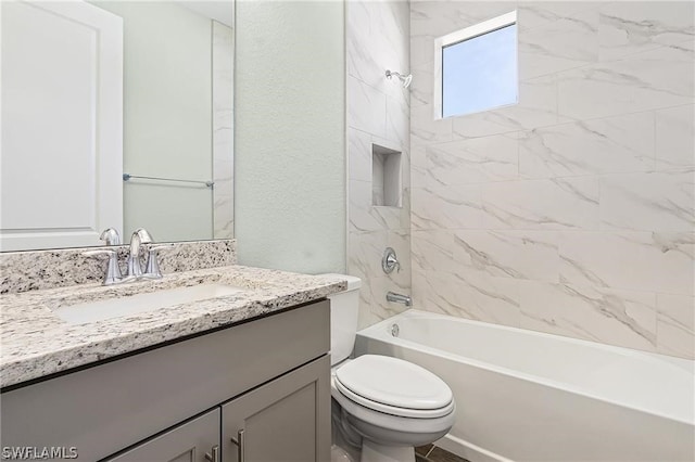 full bathroom featuring vanity, tiled shower / bath combo, and toilet