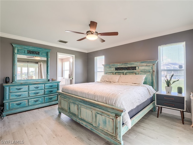 bedroom featuring ceiling fan, connected bathroom, multiple windows, and light hardwood / wood-style floors