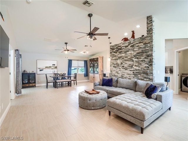 living room with ceiling fan, washer / clothes dryer, high vaulted ceiling, and light wood-type flooring