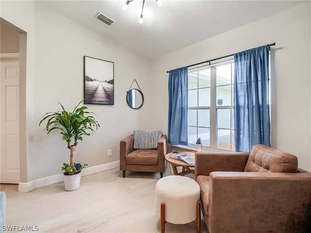 sitting room featuring light wood-type flooring and vaulted ceiling