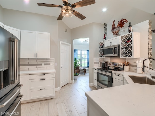 kitchen with stainless steel appliances, sink, ceiling fan, and white cabinets