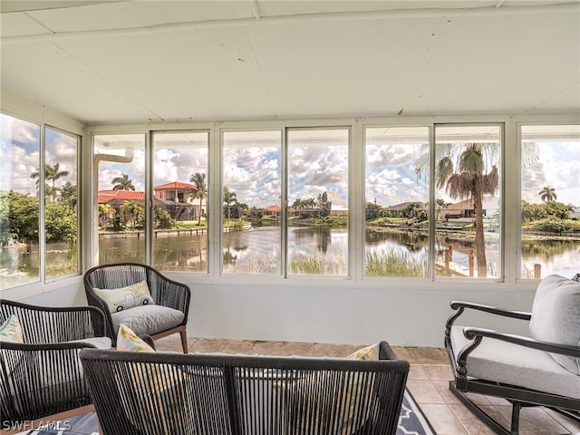 sunroom featuring a wealth of natural light and a water view