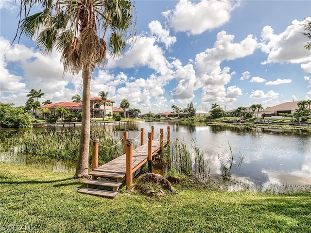 dock area with a lawn and a water view