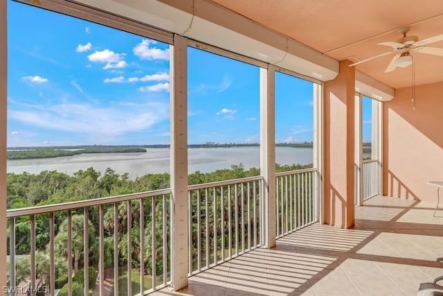 unfurnished sunroom with a water view and ceiling fan