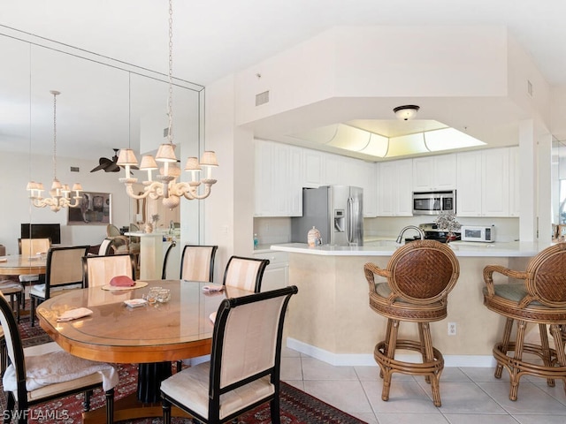 dining space featuring light tile patterned floors and a notable chandelier