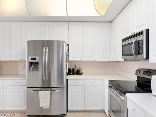 kitchen featuring white cabinetry, stainless steel appliances, and light tile patterned floors